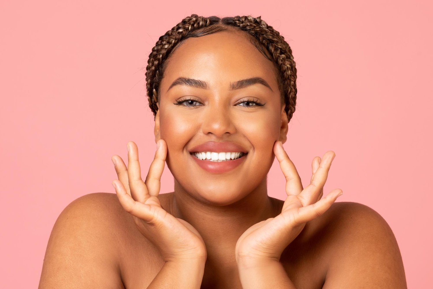 attractive-black-woman-touching-face-moisturizing-skin-pink-background